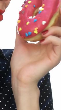 Tarz sahibi bir topuzu olan, dudaklarına canlı bir çörek getiren çekici bir retro kız. Kalın kırmızı ruju ve benekli gömleği klasik bir cazibe yayıyor. Tatlı ve nostaljik bir atmosfer yaratıyor.