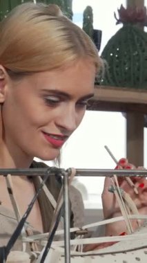 Neşeli genç bir kadın heykeltıraş, güneşli atölyesindeki eşsiz seramik bir parçayı kibarca süslerken mutluluk saçıyor. Bu canlı sahne yaratıcılığın ve adanmışlığın ruhunu özetliyor. Sanatsal yeteneğinin altını çiziyor.