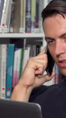 Çalışmalarına çok dalmış yakışıklı genç bir adam, canlı bir üniversite kütüphanesinde dizüstü bilgisayarı üzerinde çalışırken bir telefon görüşmesi yapıyor. Etrafı renkli kitaplıklarla çevrili, teknoloji ve eğitimin kaynaşmasına örnek olarak,