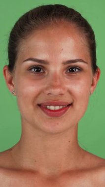 Neşeli genç bir kadın, neşeli yeşil bir krom anahtara dayanan gözlerini gevrek salatalık dilimleriyle neşeli bir şekilde kapatırken mutluluk saçıyor. Bu canlı görüntü, özbakım ve gençleşme ruhunu somutlaştırıyor, izleyicileri şımartmaya davet ediyor.