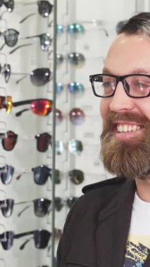 Neşeli, sakallı bir adam, parlak, modern bir optik mağazasında göz kamaştırıcı bir dizi gözlükçüyle çevrili profesyonel bir optometristle canlı bir tartışmaya girer. Davetkar atmosfer sıcaklık ve uzmanlık yayarak,