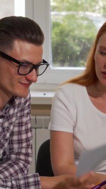 Genç iş adamlarından oluşan canlı bir üçlü, parlak ve modern bir ofiste işbirliği yaptıkları için pozitiflik yayıyor. İki kendine güvenen iş kadını ve hevesli erkek meslektaşları, çalışırken yenilikçi fikirleri paylaşarak canlı bir tartışmaya giriştiler.