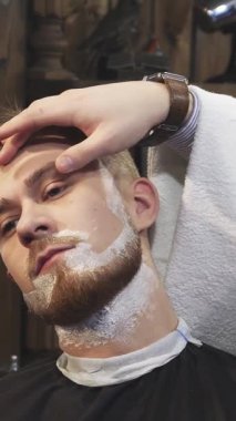 Yakın plan çekimde yakışıklı genç bir adam berber dükkanında klasik bir traş oluyor. Yetenekli bir berber ustalıkla ustalıkla ustura kullanıyor. Klasik dekor ve yumuşak ışıklandırmayla zenginleşen davetkar atmosfer, bu tımar ritüelini...