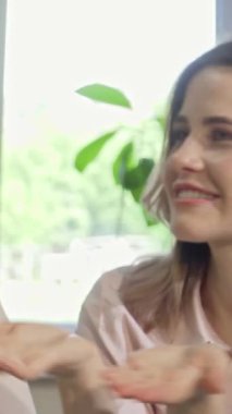 Işıl ışıl bir üniversite öğrencisi, çalışmalarını birlikte yürütürken arkadaşları tarafından çevrelenmiş kameraya parlak bir şekilde gülümsüyor. Bu canlı sahne, hayat dolu bir üniversite kampüsündeki işbirliği ve neşe ruhunu simgeliyor.