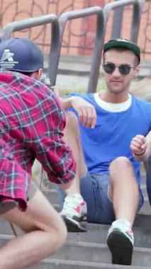 Canlı bir üçlü, dışarıda güneşli bir anın tadını çıkarırken, bir arkadaşı diğer ikisinin merdivenlerde poz verirken eğlenceli bir şekilde fotoğraflarını çekiyor. Bulaşıcı kahkahaları ve enerjik enerjileri, dostluğun özünü yayarak, kaygısız ruhun...