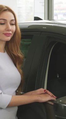 Işıl ışıl genç bir kadın, parlak ve modern bir bayilikte, parlak, yeni arabasının yanında başparmağıyla mutluluk saçar. Bu canlı sahne, yeni bir arabanın zarafetini ve heyecanını gözler önüne sererek araba sahibi olmanın coşkulu neşesini yakalıyor.