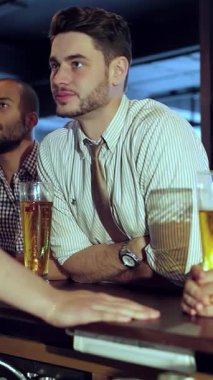 Kahkahalarla dolu canlı bir barda, dört genç işadamı büyük ekranda heyecan verici bir futbol maçını kutlamak için buzlu bira bardaklarını kaldırdı. Bulaşıcı heyecanları ve yoldaşlıkları canlı atmosferden yayılarak...