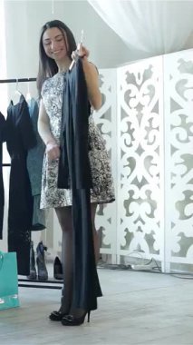 Üç şık kız arkadaş şık bir butikte toplanıp canlı alışveriş torbalarıyla çevrili şık kıyafetleri tartışırlar. Neşeli ifadeleri ve neşeli jestleri heyecan saçıyor, moda keşfi yapmanın heyecanını yakalıyor.