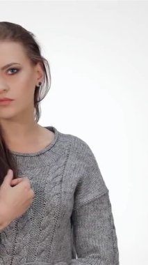 Işıl ışıl, esmer saçlı genç bir kız, el değmemiş beyaz bir fonda neşe içinde poz verirken neşe saçıyor. Neşeli ifadesi ve rahat gri süveteri gençlik enerjisi ve kendine güveni yayıyor. Seyircileri onun tadını çıkarmaya çağırıyor.