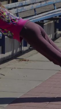 Ateşli genç bir kız tutkulu bir şekilde stadyumda jimnastik yapıyor etkileyici atletizmini ve sarsılmaz dikkatini sergiliyor. Canlı, renkli spor kıyafetleri içinde, kararlılıkla öne eğiliyor, somut güç ve adanmışlıkla.