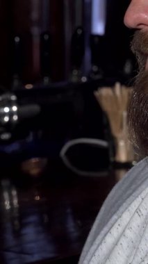 Sakallı bir adam köpüklü bira içmekten zevk alır, mutlu gülüşü rahat bar atmosferini aydınlatır. Sıcak, davetkar renkler ve kırsal dekor bu saf keyif ve dostluk anını güçlendiriyor.