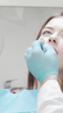 Göz kamaştırıcı gülümsemesini kameraya gösteren ışıl ışıl genç bir kadın diş kontrolünden sonra saf neşe saçıyor. Parlak, modern klinik düzenlemesi, kendine olan güvenini ve memnuniyetini arttırıyor.