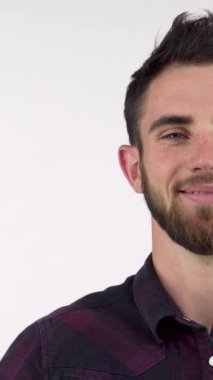 Neşeli sakallı bir adam, kendine güvenen bir gülümseme ile ışıldıyor, olumlu ve başarılı bir hava yayıyor. Bu canlı görüntü, motivasyon teması ve içeriği canlandırmak için ideal hale getirerek başarı ve onay ruhunu yakalar.