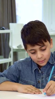 Çekici bir baba ve küçük esmer oğlu keyifle masada keyifli bir çizim seansına dalmış, gülücüklerini ve yaratıcılıklarını paylaşıyorlar. Genç Afrikalı Amerikalı adam heyecanlanan çocuğuyla ilgilenir ve gururla...