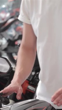 Büyüleyici bir gülümsemesi olan genç beyaz bir adam, parlak siyah bir motosikletin yanına eğiliyor, cilalı benzin deposunu hayranlıkla okşuyor. Bu dinamik sahne motosiklet sahibi olmanın heyecanını yansıtıyor, hız tutkusu ve...