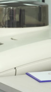 Yakın plan çekimde, pembe laboratuvar önlüklü, mavi eldivenli, kendini işine adamış bir kadın bilim adamını, gözlemlerini titizlikle bir panoya kaydederken, canlı kan örneklerini ustalıkla yönetirken gösteriyor. Bu dinamik sahne hayati önemin altını çiziyor.