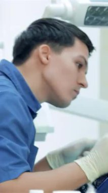 Parlak ışıkla dolu modern bir diş kliniğinde, kendini işine adamış bir diş hekimi hastanın dişlerini titizlikle döverken, neşeli bir bayan asistan da umut verici bir onay sunuyor. Bu canlı sahne diş bakımındaki sinerji ve pozitifliği vurgular.