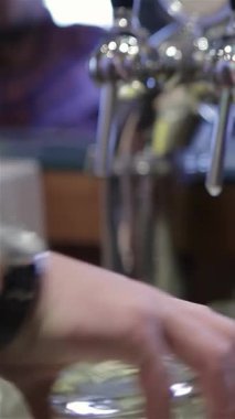 Yakından çekilen bir fotoğraf yetenekli bir barmenin elini parlak bir bardaktan parlak bir bardağa ustalıkla bira dökerken yakalıyor ve nefis köpüklü bir kafa oluşturuyor. Bu canlı sahne, canlı bar kültürünün vücut bulmuş halidir.