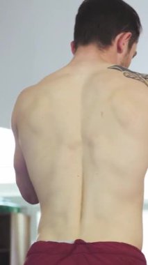 Doğal ışıkla dolu canlı bir spor salonunda, kaslı genç bir adam antrenörüyle antrenman yaparken hem kararlılık hem de odaklanmayla boks maharetini sergiliyor. Heyecan verici atmosfer profesyonel sporların özünü yansıtıyor.