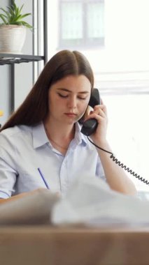 Kendini işine adamış genç bir bayan tasarımcı, doğal ışıkla dolu şık ve modern bir ofis tarafından çevrelenmiş bir telefon konuşmasına dalmış durumda. Enerjik atmosfer yaratıcılığını ve profesyonelliğini sergilerken, bir meslektaşı titizlikle ölçüyor.