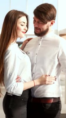 Zarif bir esmer adam şık bir arabayı işaret ederken şık kız arkadaşı öne eğilip heyecan saçarak coşkuyla parıldıyor. Işıldayan araçlarla dolu, parlak, modern bir galeri heyecan verici bir atmosfer yaratıyor.