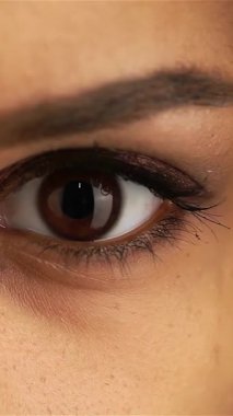 Bu çarpıcı yakın çekim genç bir Afro-Amerikalı kızın büyüleyici koyu gözlerini yakalıyor, sıcaklık ve duygu saçıyor. Hassas kirpikleri ve kusursuz cildiyle çerçevelenmiş etkileyici bakışları sizi gençliğin güzelliğini ve masumiyetini keşfetmeye davet ediyor.