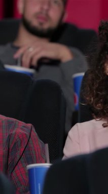 Genç bir çift, büyüleyici bir filme dalmışken rahat tiyatro koltuklarına kıvrılıp kahkahalarını ve heyecanlarını paylaşıyorlar. Patlamış mısır ellerinde ve çevrelerinde canlı bir atmosferle mükemmel bir film gecesinin neşesini somutlaştırıyorlar.