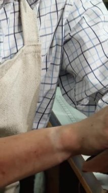 Neşeli genç bir ayakkabıcı sıcak ve davetkar atölyesinde el yapımı ayakkabılarını ustalıkla cilalarken mutluluk saçıyor. Bu canlı sahne, her ayakkabının bir hikaye anlattığı ayakkabı imalatının kendini adamışlığını ve sanatını güzel bir şekilde vurgular.