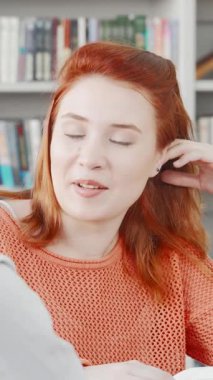 Birinde dalgalı siyah saçlı, diğerinde parlak kırmızı bukleli iki hevesli genç kadın renkli bir üniversite kütüphanesindeki projeleri hakkında derin bir tartışma içindeler. Animasyon ifadeleri ve dinamik jestleri...