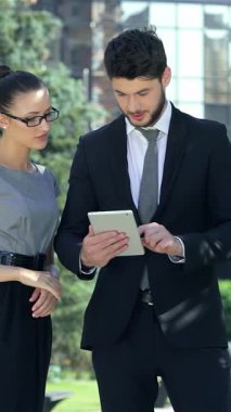 Kendine güvenen bir işadamı ve başarılı bir iş kadını canlı bir şehir vahasında bir tableti incelerken hareketli bir tartışmaya girişirler. Şık profesyonel kıyafetleri ve anlamlı yüzleri, bir arka planda belirlenen hırs ve takım çalışmasına ışık saçıyor.