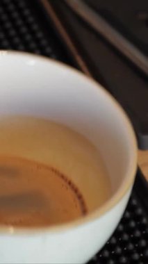 Yetenekli bir erkek barista, sıcaklığı yayıyor, kadife buğulanmış sütü zengin bir espressoya döküyor, karışık latte sanatı yaratıyor. Kaliteli dekor ile süslenmiş rahat kafe, taze demlenmiş kahvenin davetkar aromasıyla doludur.