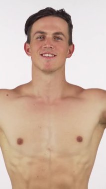 Neşeli genç bir vücut geliştirici, kameraya parlak bir gülümseme gösterirken kendine güven ve canlılık saçarak etkileyici pazılarını esnetir. Bu dinamik görüntü, güç ve kararlılığın özünü yakalar. Heykel şeklindeki fiziğini,