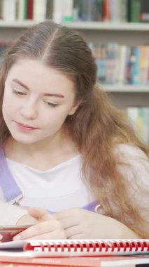 Üç neşeli genç kız, keyifli bir anı paylaşırken akıllı bir telefona sarılmış, rahat bir okul kütüphanesinde kahkahalara boğuldular. Bulaşıcı sevinçleri uzayda yayılıyor. Ortadaki arkadaşlık ve işbirliğinin özünü vurguluyorlar.