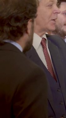 İş dünyasından çeşitli profesyoneller ofiste canlı bir tartışmaya tutkulu bir şekilde giriştiler. Takım elbiseli, kıdemli, gri saçlı bir adam, kapaklı çizelgede fikirleri resmediyor. Sahne enerji ve işbirliği yayıyor, bir karışım sergiliyor