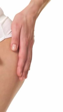 Kafkasyalı bir kadının ellerinin uyluğunun üzerinde süzülürken yakın plan görüntüsü pürüzsüz bir ten ve hassas bir dokunuşu açığa çıkarıyor. Bu samimi an, kendine bakmanın ve sağlığın somutlaştığı huzur ortamında rahatlama ve güzellik hissi uyandırıyor.