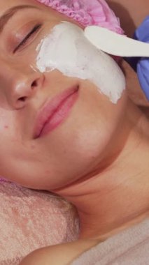 Mutluluk dolu genç bir kadın, sakin bir güzellik kliniğinde gözleri nazikçe kapalı, rahatlatıcı bir yüz maskesi uygulamasının tadını çıkararak rahatlıyor. Güzellik uzmanları, eldivenlerle süslenmiş, zarif bir şekilde maskesini takıp, göz alıcı tenini güçlendiriyor ve...