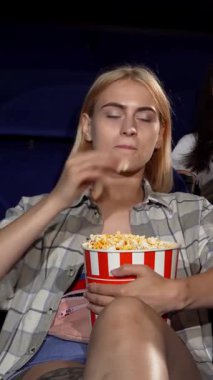 Çekici bir genç adam, sıcak bir sinemada iki güzel kadını kucaklıyor, kahkahaları bir film galasının heyecanı arasında yankılanıyor. Canlı atmosfer neşe, dostluk ve patlamış mısırın enfes aroması ile dolu. Mükemmel bir film yaratıyor.