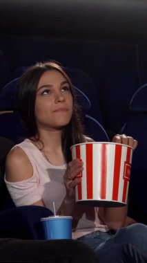 Çekici bir genç adam, sıcak bir sinemada iki güzel kadını kucaklıyor, kahkahaları bir film galasının heyecanı arasında yankılanıyor. Canlı atmosfer neşe, dostluk ve sinema sihriyle doludur.