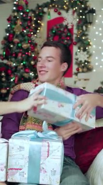 Sıcak süveter ve eşarplara sarılı neşeli bir çift, güzel paketlenmiş Noel hediyelerini sıcak bir oturma odasında değiş tokuş ediyorlar. Büyüleyici sahne yanıp sönen ışıklar ve ışıldayan bir Noel ağacı ile aydınlatılır.