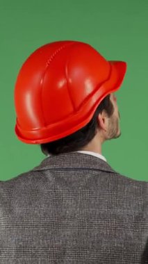 Cesur kırmızı kasketli bir erkek müteahhit, canlı yeşil renkli bir ekrana özgüvenle bakıyor. Bu dinamik imaj, inşaat endüstrisindeki yenilik ve profesyonelliğin ruhunu somutlaştırıyor.