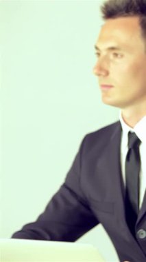 Biri parlak siyah takım elbiseli, diğeri şık gri takım elbiseli iki işadamı, canlı bir iş konferansında bir konuşmacı tarafından büyüleniyorlar. Onların odaklanmış ifadeleri ve coşkulu alkışları, değerli olan için derin bir takdiri yansıtır.