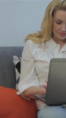 Pürüzsüz, turuncu minderlerle süslenmiş, parlak gri bir kanepeye kurulmuş parlak sarı saçlı, neşeli tipler. Yumuşak yastıklarla ve dingin bir atmosferle dolu güneşli oturma odası yaratıcılığı ve...