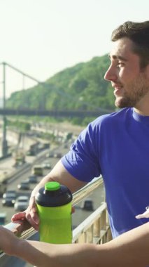 Formda bir adam ve kız arkadaşı canlandırıcı bir koşudan sonra sabah güneşinin tadını çıkararak neşeli bir sohbet ederler. Hareketli bir şehir manzarasına tepeden bakan, onların ışıl ışıl gülümsemeleri mutluluğu ve derin bir bağlantıyı yansıtır, canlı bir yaşam tarzını somutlaştırır.