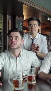 Enerjiyle dolu canlı bir barda, dört canlı iş adamı, buzlu bira bardaklarını kaldırır, televizyonda keyifli bir maç izlerken tezahürat ve tezahürat yaparlar. Hayat dolu atmosfer yoldaşlık ve neşe ile uğulduyor.