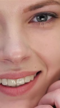 Büyüleyici mavi gözleri ve sıcak bir gülümsemesi olan ışıl ışıl sarışın bir kadın. Kusursuz cildi el değmemiş beyaz bir arka planda parlıyor. Bu yakın plan portre, doğal makyajının zarafetini vurgulayarak onun gençlik cazibesini güzel bir şekilde yakalıyor.