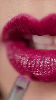Büyüleyici bir yakın plan, çekici bir kadının dudaklarını ortaya çıkarır. Yetenekli bir makyaj sanatçısı zengin, kanlı bir ruju ustalıkla sürüp güzelliğin sanatını ön plana çıkarır. Parlak tonu kusursuz cildine çarpıyor. Çekici bir kontrast oluşturuyor.