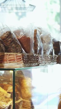 Lezzetli genç bir çift, sıcak ve davetkar bir pastanede cazip bir hamur işi gösterisini keşfederken neşe içinde birbirlerine yakın duruyorlar. Sevecen gülümsemeleri ve taze pişmiş gıdaların zengin aroması romantik bir atmosfer yaratıyor.