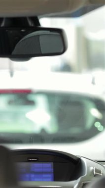 Kendinden emin genç bir kadın sürücü koltuğunda oturur ve heyecan verici bir test sürüşüne hazırlanırken dikiz aynasını ustalıkla ayarlar. Aracın parlak, modern iç tasarımı onun heyecanını yansıtan ileri teknoloji ile parıldıyor.