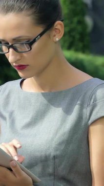 Üç dinamik iş kadını şık resmi giysiler içinde tabletlerine daldırılırken, bir tanesi canlı bir şirket atmosferini somutlaştırmak için telefonunda güvenle konuşuyor. Odaklanmış ifadeleri ve şık kıyafetleri profesyonellik saçıyor.