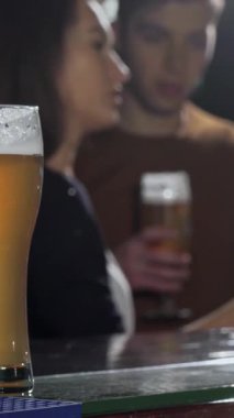 Cilalı tezgahın üzerinde güzel işlenmiş bir bira bardağı parıldarken, neşeli bir grup arkadaş şen şakrak bir barda kadehlerini şaklatıyorlar. Bar ışıklarının sıcacık parlaklığı herkesi rahatlamaya çağıran samimi bir ortam yaratıyor.